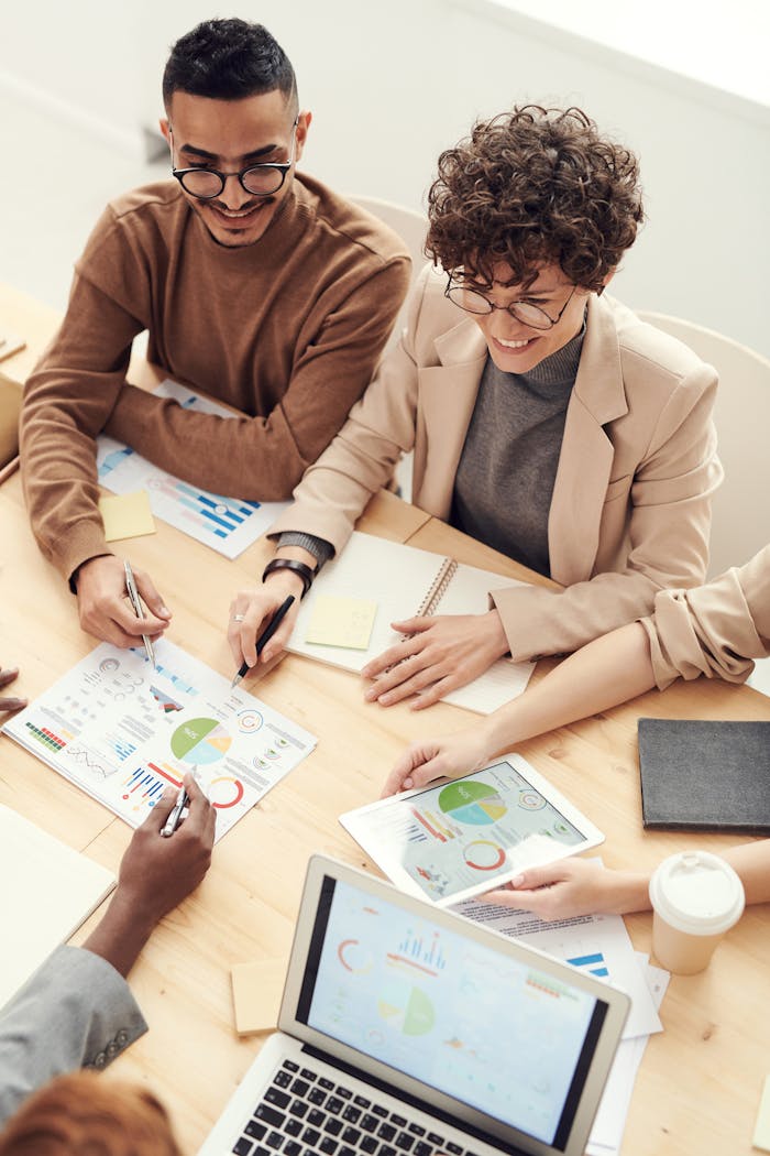 A diverse team of professionals collaborating over charts and graphs during a business meeting.